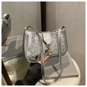 Close-up of shiny silver sequins and metal buckle on the stylish crossbody shoulder bag