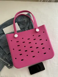Makro-Detail der rosaroten EVA-Strandtasche mit atmungsaktivem Lochmuster und Kontrastgriff