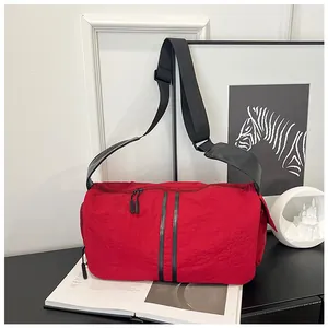 Detalle del bolso bandolera de nailon rojo con rayas negras dobles y correa ajustable