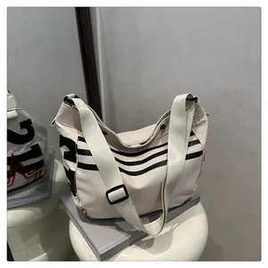 Détail du sac fourre-tout blanc cassé avec graphismes 21 noirs et large bandoulière
