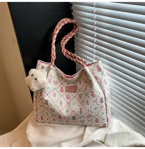 Detail of floral tote bag featuring pink bear patterns and plush star charm accessory