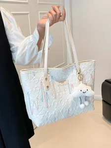 White quilted tote bag with colorful wave embroidery and plush cloud charm detail