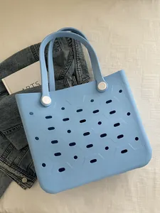 Himmelblaue EVA-Strandtasche mit Belüftungslöchern und weißen Schnallengriffen in Flat-Lay-Optik