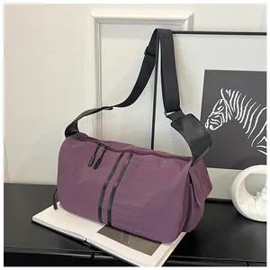 Detalle del bolso de viaje de nailon violeta impermeable con cremalleras y correa negra