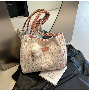 Detail of floral bear print canvas tote bag with woven handles and rabbit plush charm