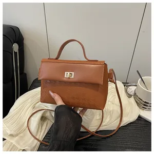 Detail of brown Kelly handbag with textured houndstooth pattern and metallic twist lock