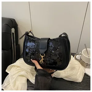 Close-up of black sequined shoulder bag featuring elegant golden metal clasp detail