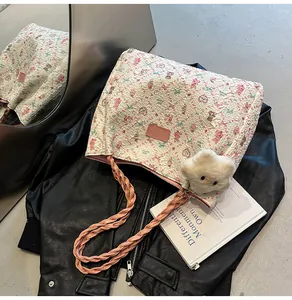 Detailed close-up of floral tote bag with pink straps on a black leather jacket backdrop