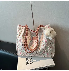 Detail of white floral tote bag with cute bear pattern and woven pink handles