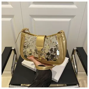 Detailed view of a gold sequin luxury shoulder bag with metallic clasp and leather handle