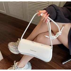 Detail view of white leather shoulder bag with FASHION & BAGS text and rope handle strap