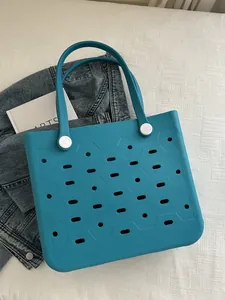 Flache Ansicht einer petrolfarbenen EVA-Strandtasche mit Wabenstruktur und Kunstbuch-Deko
