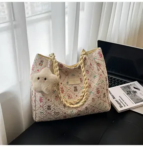 Detail of floral tote bag with cute bear pattern, star plush charm and woven handles