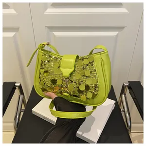 Detail of green sequin handbag featuring metallic luster and golden buckle closure