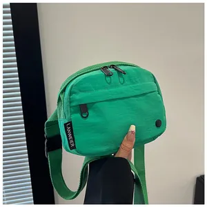 Detail view of the bright green nylon shoulder bag with its durable woven strap and buckle