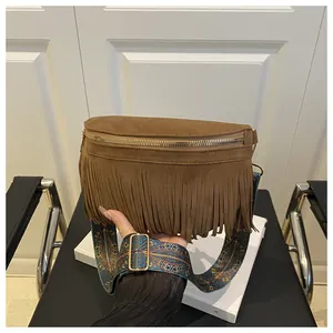 Close-up of brown suede fanny pack with fringe tassels and ethnic patterned wide strap