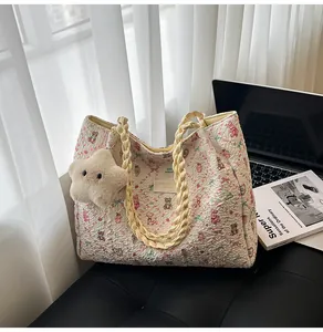 Detail of floral bear print tote bag with textured fabric and star plush charm