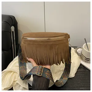 Detail of brown suede crossbody bag with fringe tassels and ethnic patterned wide strap