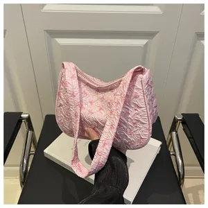 Detailed shot of pink bow print quilted shoulder bag with bubble fabric texture