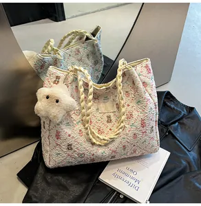 Close-up of quilted floral tote bag with cute bear patterns and woven cream handles