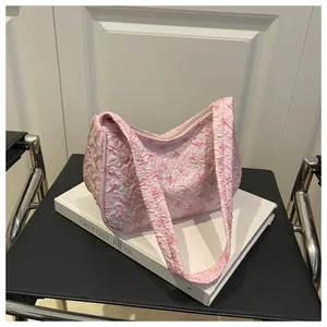 Detail of pink quilted hobo bag with bow jacquard pattern and textured bubble fabric