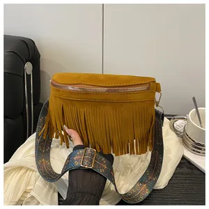Detail of yellow suede crossbody bag with long tassels and bohemian printed shoulder strap