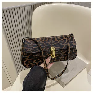 Detail van de tas met luipaardprint voorzien van een gouden ovale draaisluiting in vintage stijl