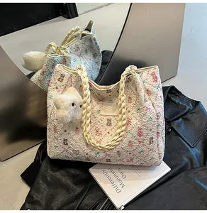 Detail of a large tote bag with cute bear prints, rope handles, and star plush charm