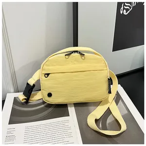 Detail view of the yellow nylon crossbody bag with dual zippers and earphone port