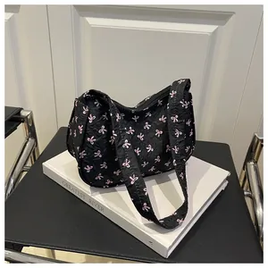 Detail of floral bow print on black pleated hobo bag with pink ribbon patterns