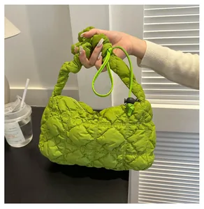 Detail of bright green quilted puffy cloud bag showing soft padded texture and drawstring