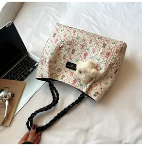 Detailed view of quilted tote bag with colorful teddy bear prints and plush lamb charm