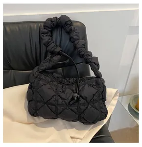 Detailed close-up of black quilted nylon puffy bag with fashionable bubble ruched handle