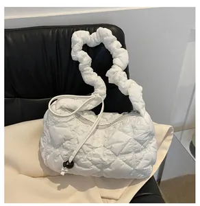 Detail of white quilted nylon bag featuring puffy cloud texture and ruched handle