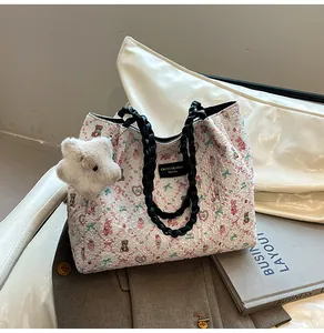 Detail of white printed tote bag featuring colorful bears, bowknots and a plush star pendant