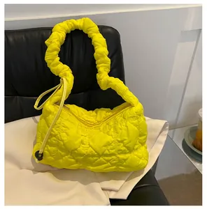 Close-up of bright yellow quilted nylon cloud bag featuring bubble texture and ruched handle