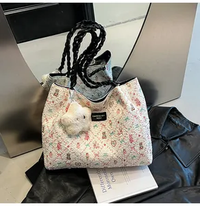 Detail of woven tote bag with cartoon bears and logo tag on a metallic background