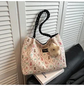 Close-up of floral bear print tote bag with woven handles and star plush charm