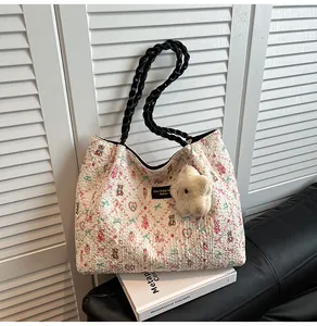 Detail of floral jacquard tote bag with teddy bear pattern and plush star accessory