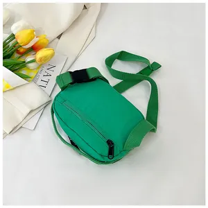 Detail of green nylon crossbody bag with adjustable strap and zipper on white background
