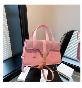 Detailed view of pink handbag featuring crystal rhinestones and golden twist lock clasp