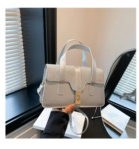Detailed view of light blue handbag featuring sparkling silver sequins and gold clasp lock