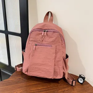 Dettaglio dello zaino in nylon rosa antico con scomparto principale e trama della tasca laterale