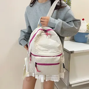 Detail of lightweight nylon backpack showing the magenta zipper and textured cream fabric
