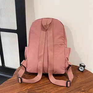 Vista posteriore dello zaino in nylon rosa con spallacci regolabili e tasche laterali