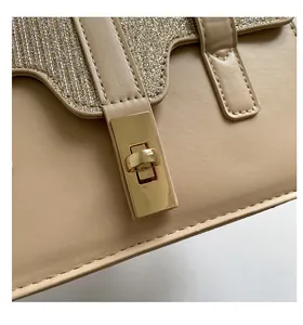 Detail view of apricot handbag showing the gold clasp and glitter fabric texture
