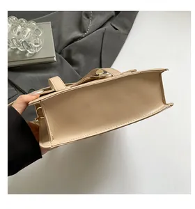 Detail of the accordion fold structure and smooth beige leather texture on the handbag
