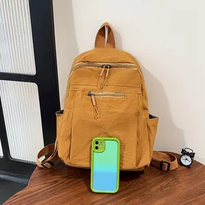 Vista dettagliata dello zaino in nylon giallo senape con texture e tasche a zip