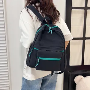 Detail of minimalist black nylon backpack with cyan contrast zippers for casual travel