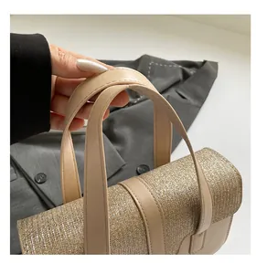 Macro detail of champagne gold sequined handbag with smooth leather top handle and texture